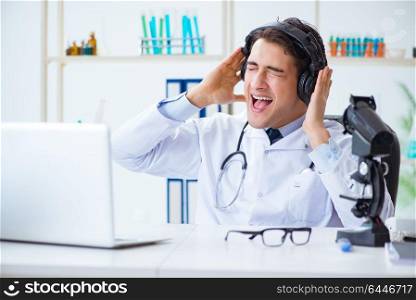 Happy excited doctor listening to music during lunch break in hospital