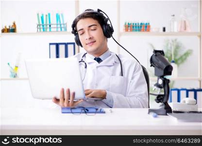 Happy excited doctor listening to music during lunch break in hospital. Happy excited doctor listening to music during lunch break in ho