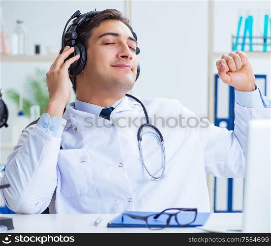 Happy excited doctor listening to music during lunch break in hospital. Happy excited doctor listening to music during lunch break in ho