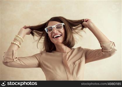 Happy excited woman dancing cheerful with wind in the hair on beige background