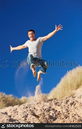 Happy Excited Young Man Jumping On A Beach