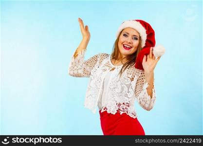 Happy excited young woman wearing santa claus red hat, on blue. Christmas holiday season.. Excited woman in christmas santa hat