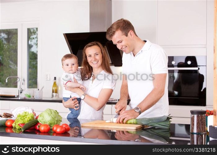 Happy family at home in the kitchen cooking, making a meal