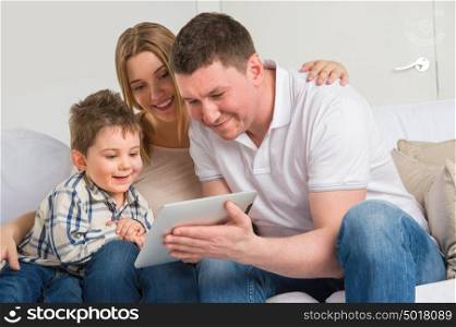 Happy family at home using electronic tablet to play together