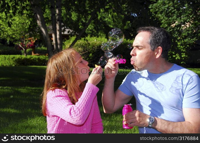 Happy family blowing soap bubbles, father and child