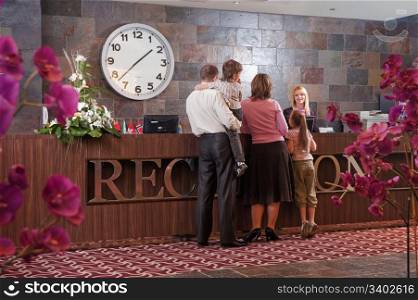 Happy family checking in at the reception desk