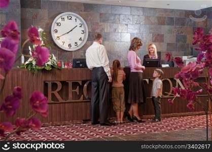Happy family checking in at the reception desk