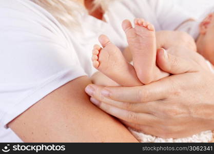 Happy Family concept. Newborn baby feet in mother hands on white background. Mom holding her Child. Beautiful conceptual image of Maternity.