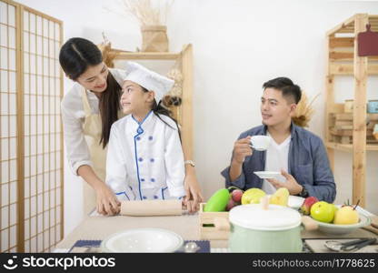 Happy family cooking biscuits together in kitchen at home for family
