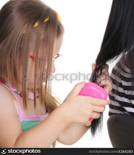 happy family, cute three years old little girl brushing her mom mother hair isolated on white