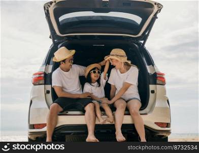 Happy Family Day. Dad, mom and daughter enjoying road trip sitting on back car, Parents and children traveling in holiday at sea beach, family having fun in summer vacation on beach with automobile