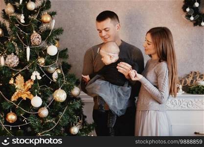 happy family decorates the Christmas tree. the family is preparing for the new year.. happy family decorates the Christmas tree. the family is preparing for the new year