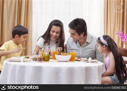 Happy family eating pizza together at restaurant