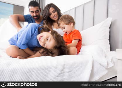 Happy family enjoying the morning in bed