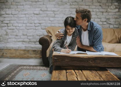 Happy family father and child daughter doing homework at home