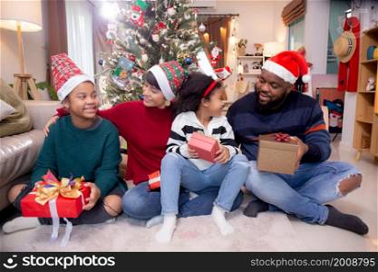 Happy family father and mother and daughter sitting and having gift box at home, celebration in xmas with surprising and enjoyment at house, thanksgiving eve, Merry Christmas.