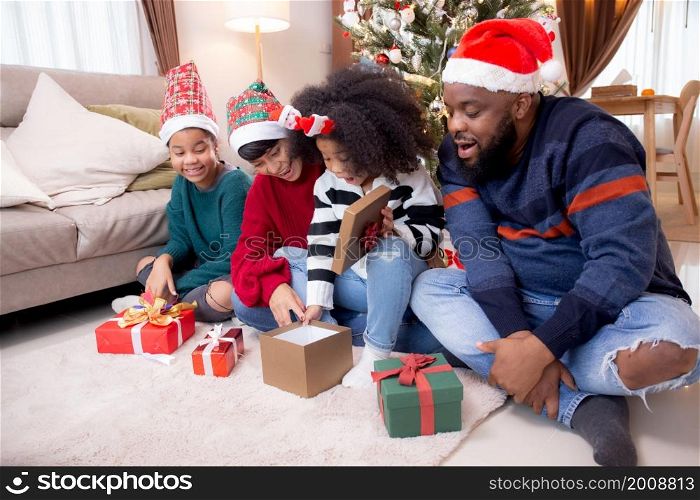 Happy family father and mother giving gift box with daughter on celebration in Christmas day at home, xmas with parent surprising children with excited at house, thanksgiving eve, Merry Christmas.