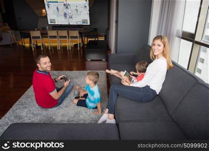 Happy family. Father, mother and children playing a hockey video game Father and son playing video games together on the floor