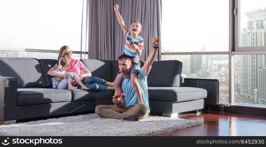 Happy family. Father, mother and children playing a video game Father and son playing video games together on the floor