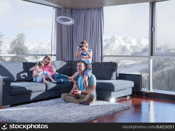 Happy family. Father, mother and children playing a video game Father and son playing video games together on the floor