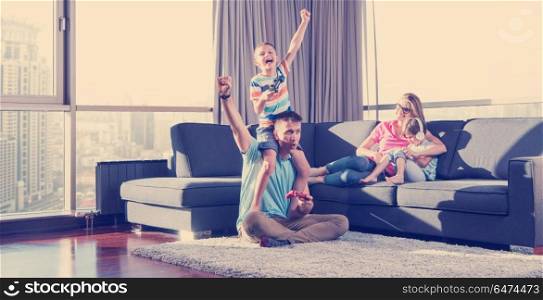 Happy family. Father, mother and children playing a video game Father and son playing video games together on the floor. Happy family playing a video game