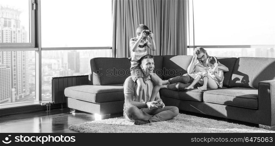 Happy family. Father, mother and children playing a video game Father and son playing video games together on the floor. Happy family playing a video game