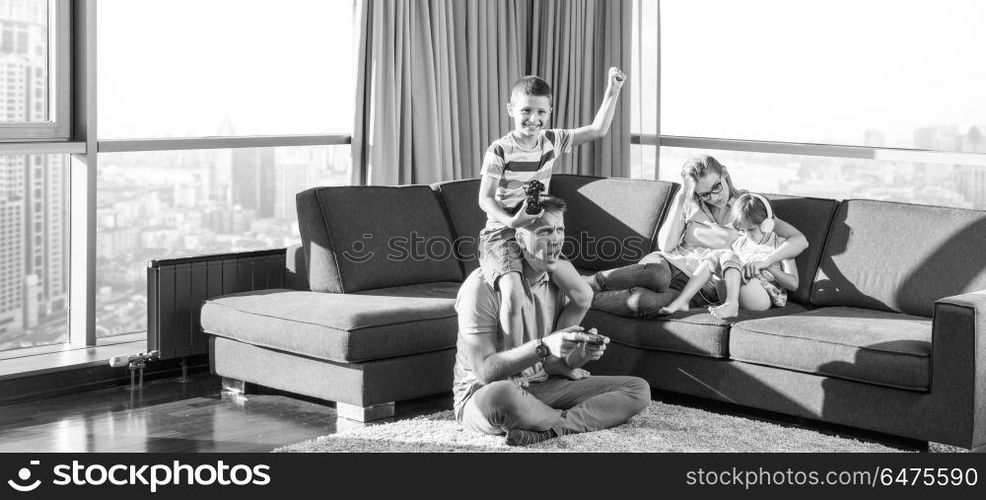 Happy family. Father, mother and children playing a video game Father and son playing video games together on the floor. Happy family playing a video game