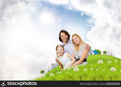 Happy family. Happy family of mother father and daughter sitting on grass