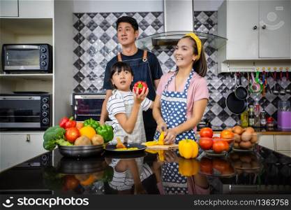 Happy Family have Dad, Mom and their little daughter Cooking Together in the Kitchen