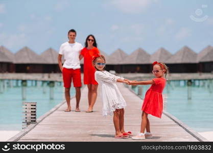 Happy family have fun on wooden jetty during maldivian vacation. Beautiful happy family have fun on wooden jetty during summer vacation