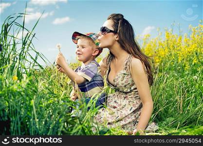 Happy family having a lot of fun with dandelions