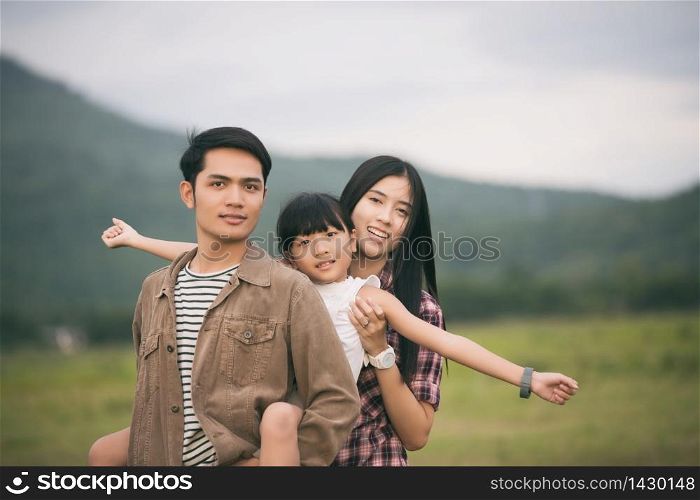 Happy family having fun and enjoying journey in the park at the sunset time