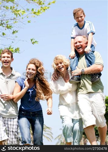 Happy family having fun in the park with three children