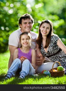 Happy family having fun outdoors in spring park against natural green background