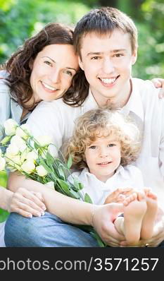 Happy family having fun outdoors in spring park against natural green background