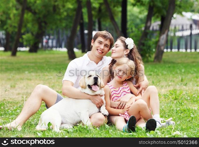 Happy family having fun outdoors. Young Family Outdoors in summer park with a dog