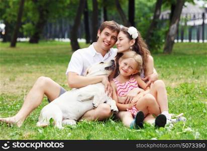 Happy family having fun outdoors. Young Family Outdoors in summer park with a dog
