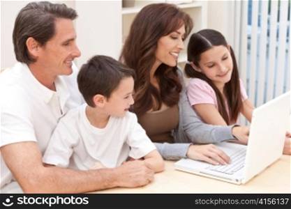 Happy Family Having Fun Using Laptop Computer At Home