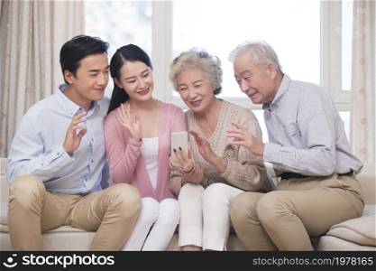 Happy family having video call on their cell phone