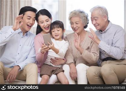 Happy family having video call on their cell phone together
