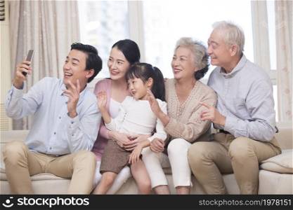 Happy family having video call on their cell phone together