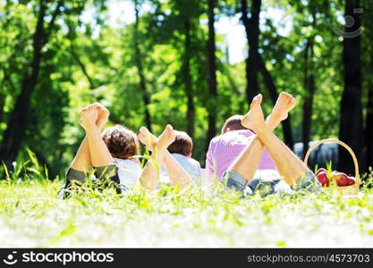 Happy family having weekend in summer park. Picnic in garden