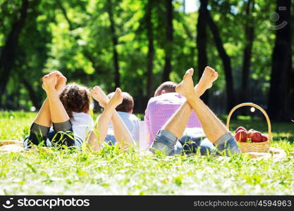 Happy family having weekend in summer park. Picnic in garden