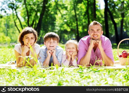 Happy family having weekend in summer park. Picnic in garden