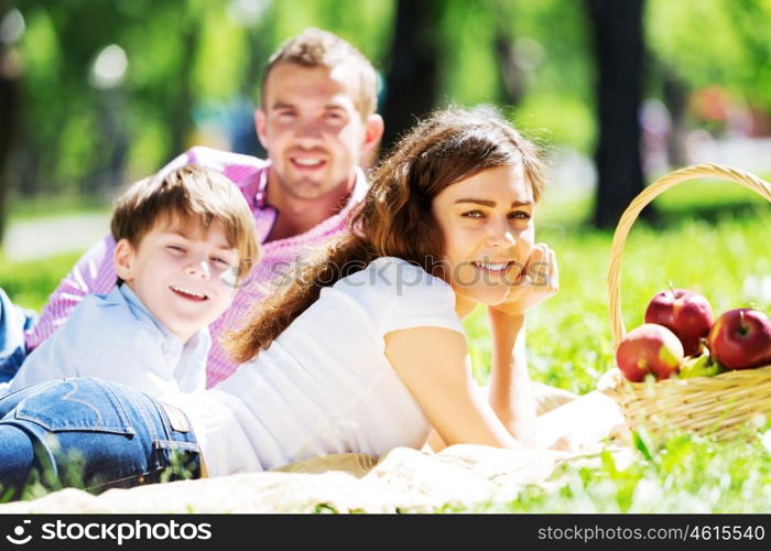 Happy family having weekend in summer park. Picnic in garden