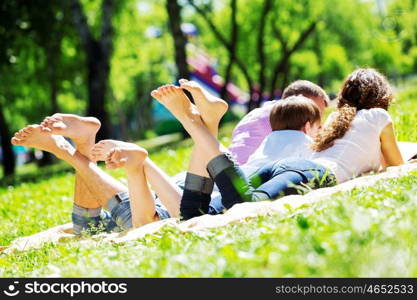 Happy family having weekend in summer park. Picnic in garden