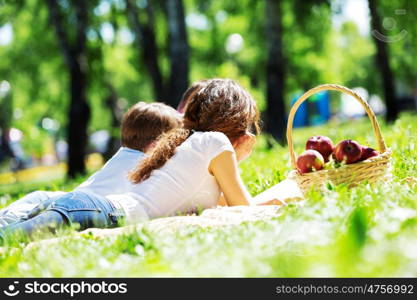 Happy family having weekend in summer park. Picnic in garden