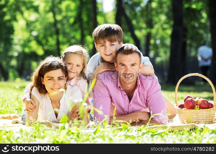 Happy family having weekend in summer park. Picnic in garden