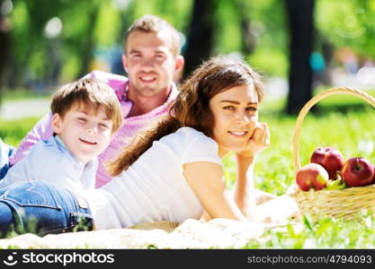 Happy family having weekend in summer park. Picnic in garden