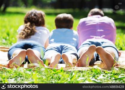 Happy family having weekend in summer park. Picnic in garden